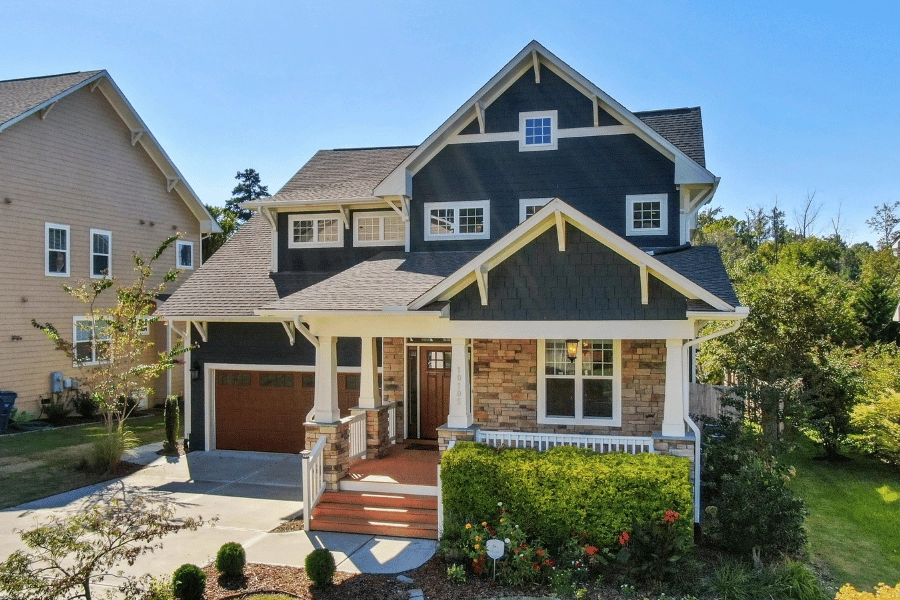 beautiful blue home with front porch and a well-maintained lawn